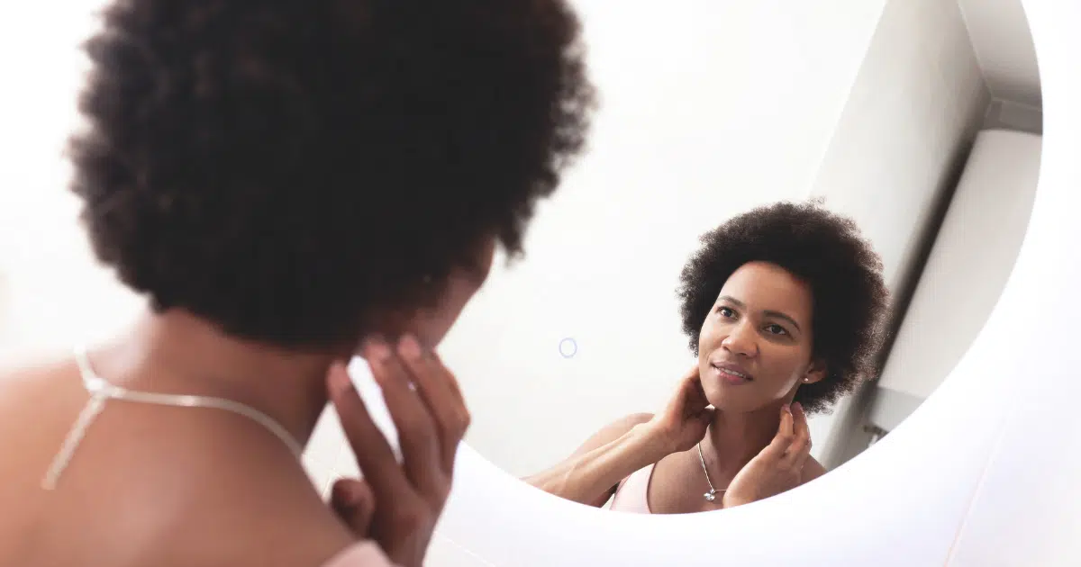 a-woman-looking-at-their-chin-in-the-mirror